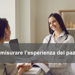 Medico sorridente seduto alla scrivania di un ambulatorio con una paziente di fronte